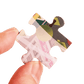 Hand holding a puzzle piece with colorful design on a transparent background
